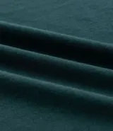 Remera de algodón color verde oscuro, corte relaxed, cuello redondo y manga corta. Presenta un pequeño estampado en el pecho con el texto "N.Y.U.S" en blanco y dos franjas blancas horizontales en cada manga.