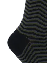 Calcetines largos hasta la rodilla con diseño de zigzag en tonos verde oliva y negro. El puño, el talón y la puntera son de color negro liso.