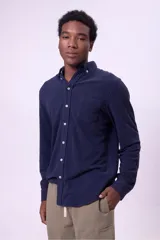 Camisa azul marino de manga larga con cuello abotonado y bolsillo en el pecho.