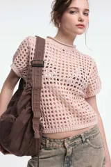 Top color arena de tejido calado con cuello redondo y mangas cortas.