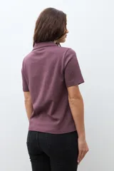 Camisa de manga corta color ciruela, con cuello camisero y cierre frontal de botones.