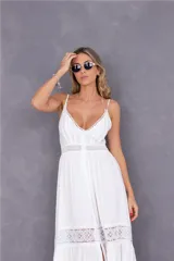 Vestido largo blanco con breteles finos, escote en V con detalle de puntilla, corte imperio con bordado en la cintura y falda con volados y detalle de puntilla en el ruedo.
