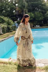 Blusa estampada con hilo metalizado, cuello redondo con volante, escote pico y manga larga abullonada.