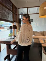 Blusa color crema de tejido calado con mangas 3/4 y cuello en V.