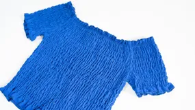 Top elastizado azul con textura arrugada y mangas cortas con volados.