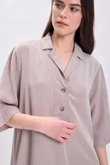 Vestido largo color visón con cuello solapado, manga corta y corte holgado.