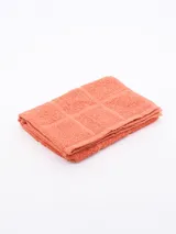 Repasador de cocina color salmón con diseño de cuadrados en relieve.