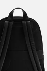 Mochila negra con textura grabada, compartimento principal con cierre de cremallera, compartimento acolchado interior para dispositivos electrónicos de hasta 13 pulgadas, bolsillo frontal con cierre de cremallera, dos bolsillos laterales planos, asa de mano y dos asas de hombro ajustables.
