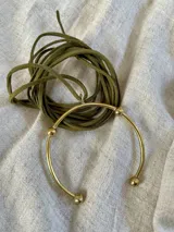 Collar con dije en bronce y cuerda de ecocuero color verde oscuro, diseño sencillo.