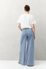 Pantalón de jean negro de calce ultra wide leg, tiro alto y silueta amplia desde la cadera hasta el bajo. Diseño clásico de cinco bolsillos y cierre con botón metálico y cremallera.
