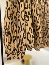 Camisa color camel con estampado animal print en negro, cuello mao y mangas largas con puños abotonados.