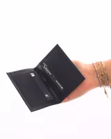 Tarjetero doble de cuero negro con forro interior. Tiene múltiples ranuras para tarjetas de crédito y documentos.