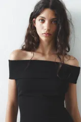 Vestido corto negro de tejido de punto, con escote recto y hombros descubiertos.