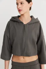 Campera color beige de mangas 3/4 con capucha y cierre frontal.