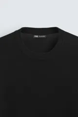 Jersey color topo de corte amplio, tejido en hilatura con mezcla de viscosa. Tiene cuello redondo, manga larga y terminaciones en rib.