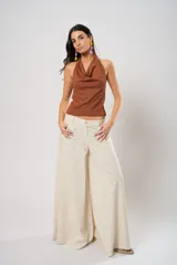 Pantalón palazzo color beige con bordados calados en forma de paisley en los laterales.