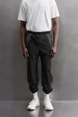 Pantalón relaxed fit confeccionado en tejido técnico ligero y elástico en todas direcciones. Cintura elástica ajustable con cordón interior, bolsillos delanteros y bajo acabado en elástico y ajustable con cremallera.