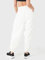 Pantalón de buzo negro de tela suave, con cintura elástica, bolsillos laterales y traseros, y elástico en los tobillos.