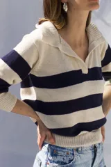 Sweater tejido artesanalmente en hilado 70% algodón y 30% acrílico, con cuello polo y rayas horizontales anchas color azul marino sobre fondo crudo.