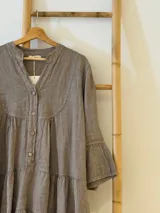 Vestido corto negro de lino, con escote en V, botones frontales y mangas largas acampanadas con volados.