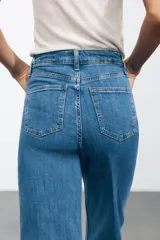 Pantalón de jean de tiro alto con trabillas en la cintura, efecto lavado y pierna ancha.