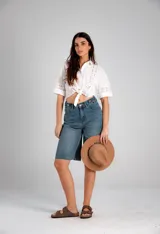 Camisa blanca de manga corta con detalles de broderie y nudo para atar en la parte delantera.