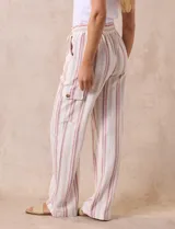 Pantalón cargo de lino color blanco, marca Marissa Olivia. Tiene pretina ancha elastizada con lazo de ajuste, bolsillos inclinados delanteros y bolsillos laterales con botón.