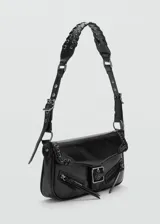 Bolso negro de diseño estilizado con detalles en metal y cierre frontal.