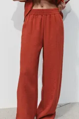 Pantalón marrón de tiro alto con cintura elástica, bolsillos delanteros y pernera ancha.