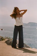 Pantalón de jean azul de corte wide leg, tiro alto, con cinco bolsillos y cierre frontal con cremallera y botón.