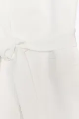 Blazer oversize color blanco confeccionado con 22% de lino. Tiene cuello solapa, manga larga con hombreras y abertura en la espalda. Incluye cinturón lazada en el mismo tejido.