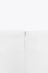 Falda pantalón negra de tiro alto con delantero cruzado y pliegues. Cierre trasero con cremallera oculta.