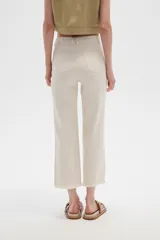 Pantalón jean blanco, recto y de calce alto con terminación desflecada.
