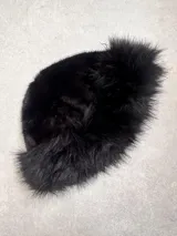 Gorro de piel sintética color negro, con forma redondeada y ala corta.