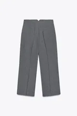 Pantalón culotte gris de tiro alto con bolsillos delanteros de vivo. Pierna ancha y cierre frontal con cremallera y gancho metálico.