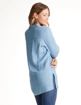 Blusa de lyocell color azul claro, con cuello camisero, escote en V y abertura frontal con tres botones. Mangas 3/4 amplias.