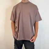 Remera lila con estampado en la espalda que incluye texto, un logo y un diseño geométrico.