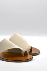 Sandalias bajas color beige con capellada cruzada de neopreno y plantilla de cuero.