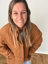 Campera color camel de corte relajado, con exterior de tejido efecto gamuza e interior acolchado. Tiene cuello alto, cierre frontal con cremallera, bolsillos laterales y bolsillo interno.