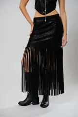 Falda midi de cuerina negra con flecos y abertura lateral.