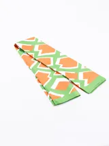 Pañuelo rectangular con estampado abstracto en tonos terracota, negro, blanco y beige.