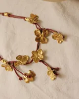 Collar corto con cordón de algodón color menta y flores de bronce.