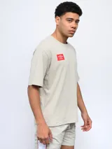 Remera color arena de corte holgado, con cuello redondo y logo de Umbro estampado en el pecho.