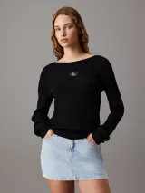 Sweater ajustado negro de canalé, con cuello redondo y insignia de Calvin Klein en el pecho.