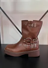 Botas de caña corta en cuero vegano marrón, con estribo y tres hebillas.