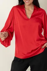 Blusa de satén en color rojo, con cuello en V y mangas abullonadas.