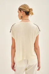 Remera negra de viscosa con escote en V, manga corta y bordado de canutillos y mostacillas color peltre en los hombros.