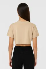 Remera cropped color beige de algodón, holgada y con cuello a la base.