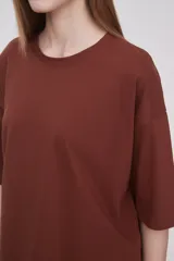 Remera color marrón de corte holgado, con cuello redondo y mangas cortas.
