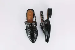 Sueco de cuero negro con cordones, ojales, hebillas y tira trasera regulable con elástico. Tiene taco cuadrado bajo.